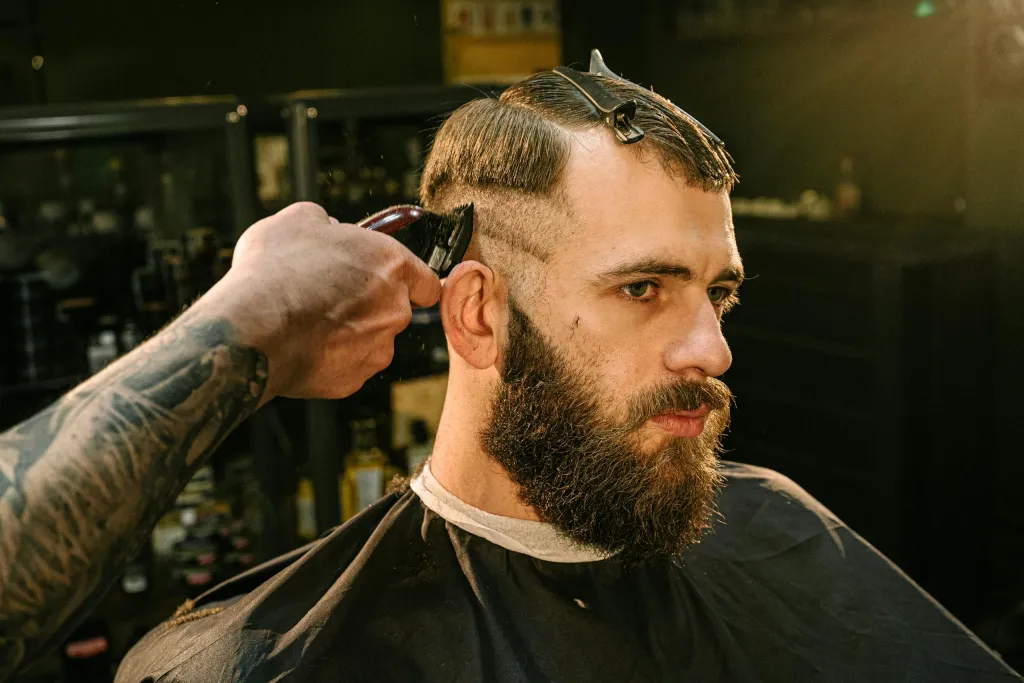 Klient v barber křesle během kompletní úpravy střihu a vousů